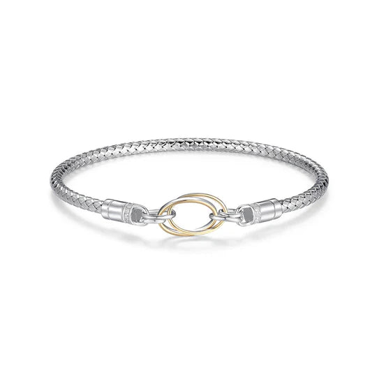 A stylish bangle featuring a loop design with sparkling diamonds, crafted from sterling silver and 14kt yellow gold. The bangle has an inner circumference of 6.75 inches.