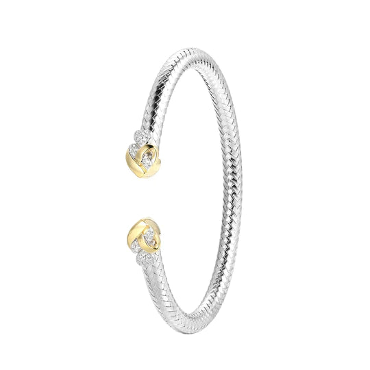 Image description: A close-up photo of the Charles Garnier CB0075 sterling silver cuff bracelet. The bracelet features a mesh design with a heart-shaped centerpiece adorned with cubic zirconia stones. The bracelet has a rhodium and yellow gold finish, giving it a luxurious look. The inner circumference measures 3.75 inches, making it suitable for a comfortable fit on the wrist.